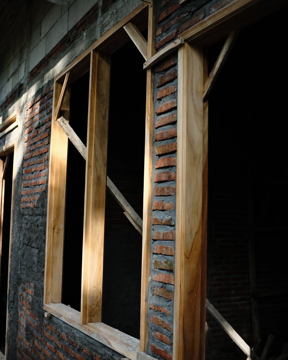 Fensteröffnungen in einer Mauerwerkswand mit eingesetzten Holzrahmen